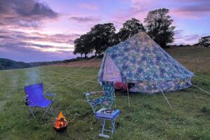 Patterned tent and firepit at dusk